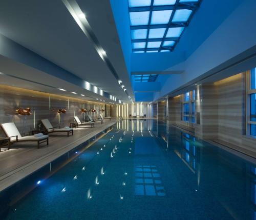 郑州郑州希尔顿酒店的一座带桌椅的游泳池