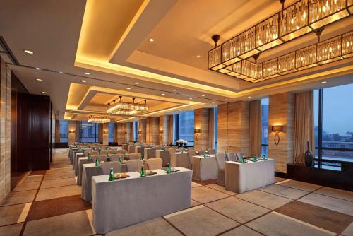 北京北京王府井希尔顿酒店的餐厅设有白色的桌椅和窗户。