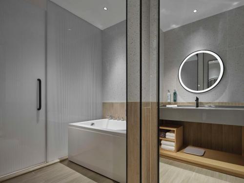天津天津华苑希尔顿花园酒店的带浴缸、水槽和镜子的浴室