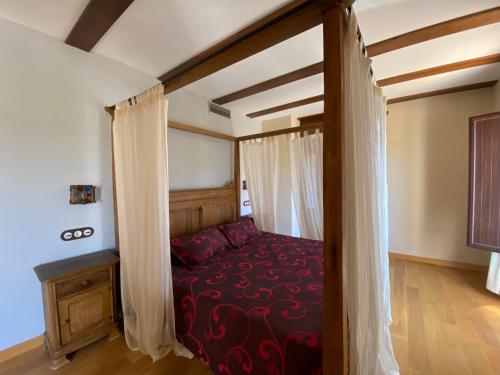 阿尔德亚达维拉德拉里韦拉Hotel Rural Centro de las Arribes的一间卧室配有一张带红色毯子的天蓬床