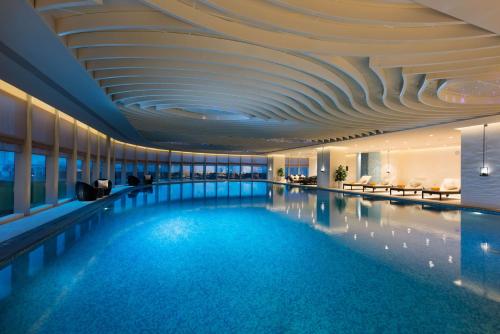 安顺安顺百灵希尔顿逸林酒店的一座拥有格子天花板的酒店游泳池