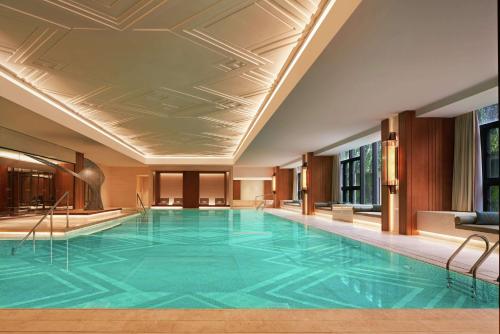 天津天津康莱德酒店的一座游泳池,位于一座拥有大型蓝色游泳池的酒店
