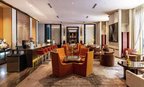 北京北京华尔道夫酒店的一间带桌椅的餐厅和一间酒吧