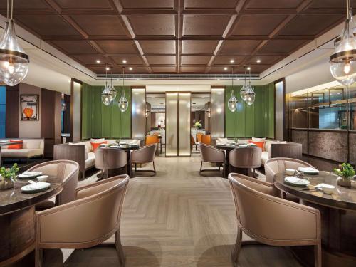 台北台北新板希尔顿酒店的餐厅的 ⁇ 染,配有桌椅