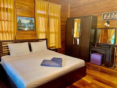 Ban Nong Chap TaoBangsaray Village Resort的一间卧室,配有一张床,上面有帽子