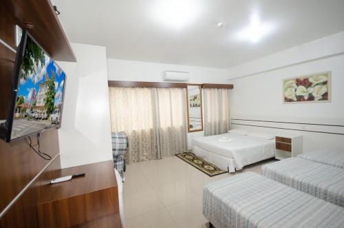 佩尼亚Hotel Penha的酒店客房设有两张床和一台平面电视。