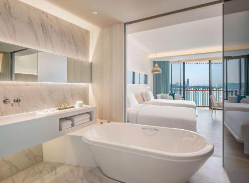 芭堤雅市中心芭堤雅希爾頓酒店 的带浴缸的白色浴室和卧室