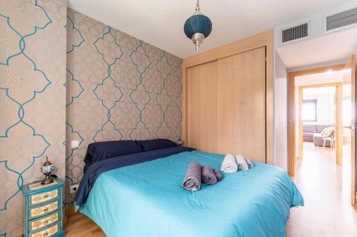 马德里Home Sweet Home的一间卧室配有蓝色的床和2条毛巾
