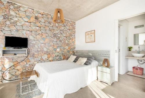 Remedios de EscaladaLuminoso y comfortable monoambienteA 25 minutos de Ezeiza的一间卧室设有石墙和床