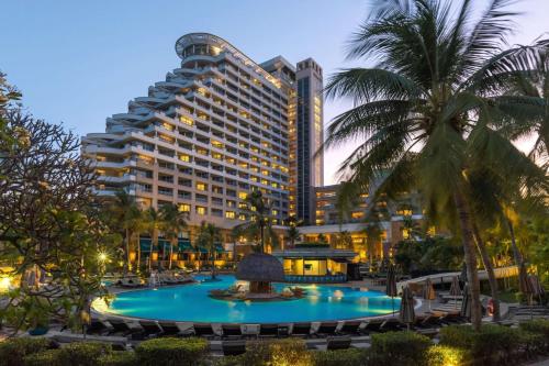 华欣Hilton Hua Hin Resort & Spa的大楼前设有大型游泳池的酒店