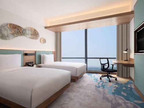雅加达Hilton Garden Inn Jakarta Taman Palem的酒店客房配有两张床和一张书桌