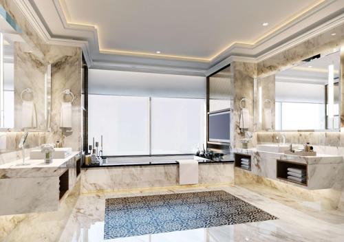 马六甲马六甲希尔顿逸林酒店的大型浴室设有两个盥洗盆和浴缸。