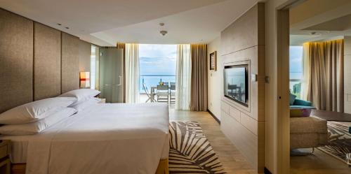 峇都丁宜槟城度假希尔顿逸林酒店的酒店客房设有一张大床和一个阳台。