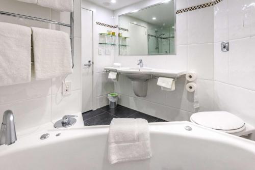 基督城公园酒庄基督城希尔顿逸林酒店的带浴缸、盥洗盆和卫生间的浴室