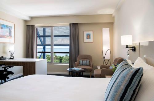 达尔文达尔文滨海希尔顿逸林酒店的配有一张床和一张书桌的酒店客房
