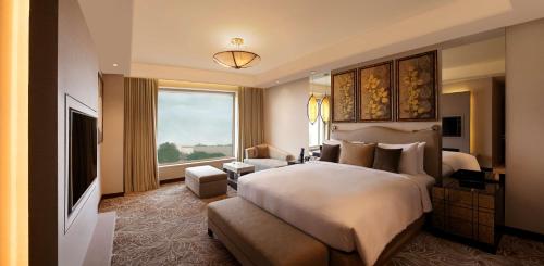 阿格拉阿格拉希尔顿逸林酒店的一间卧室设有一张大床和一个大窗户