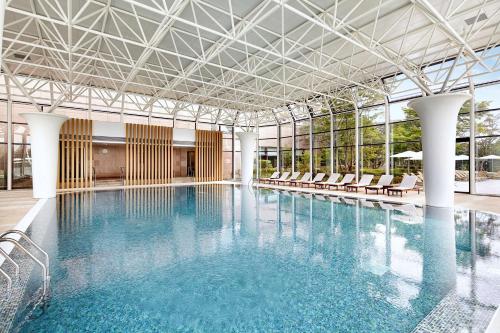 庆州庆州希尔顿酒店的大楼内带椅子的大型游泳池