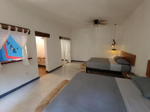 坎昆Jungle Lodge CANCUN AEROPUERTO的一间卧室配有一张床,另一间卧室配有两张床