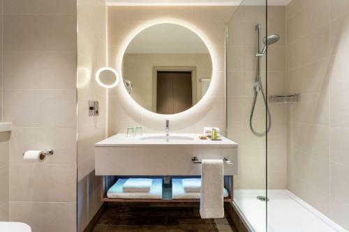 阿伯丁Hilton Aberdeen TECA的一间带水槽、镜子和淋浴的浴室