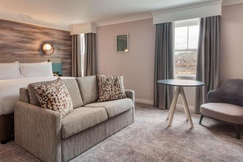 巴斯DoubleTree by Hilton Bath的酒店客房设有一张沙发和一张床