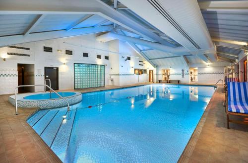 布里斯托北布里斯托尔希尔顿逸林酒店的一座大型游泳池,位于一座带大型游泳池的建筑内