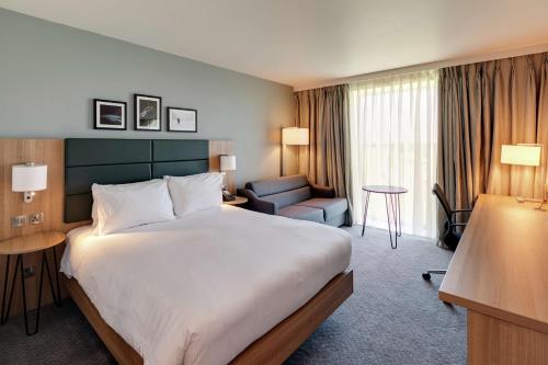 唐克斯特唐卡斯特赛马场希尔顿花园酒店的酒店客房带一张大床和一把椅子