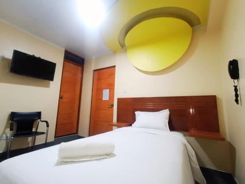 瓦拉斯ROYALS RESORT的卧室设有白色的床和黄色的天花板