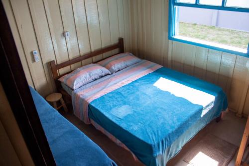 伊塔波阿Casa das Ondas的一间卧室设有一张床和一个窗口