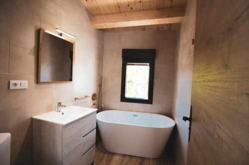 里奥帕尔CASA RURAL EL PADRONCILLO的浴室配有白色浴缸和水槽