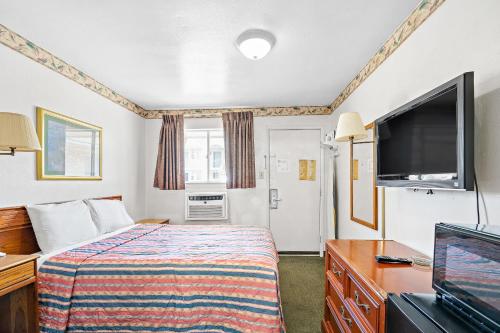 基林Friendship Inn Hotel的配有一张床和一台平面电视的酒店客房