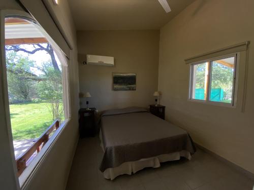 库拉布罗切罗镇Complejo Turístico Casaflor的一间卧室设有一张床和一个大窗户