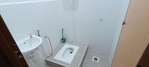 瓜拉丁加奴ADIMA Homestay的白色的浴室设有卫生间和水槽。