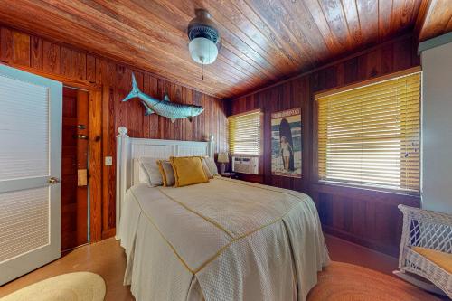 安娜玛丽亚The Wee Cottage的卧室配有一张床铺,位于带木墙的房间内