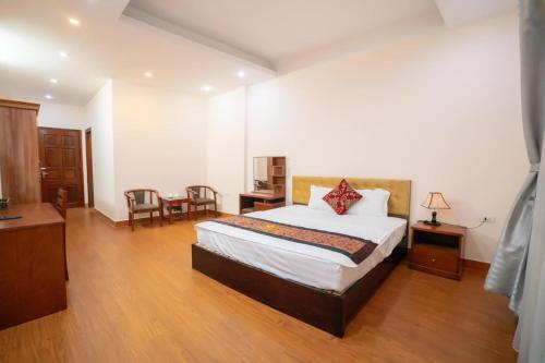 太原省Hoang Yen Hotel - Gần đại học Sư Phạm TN的卧室配有一张床和一张桌子及椅子