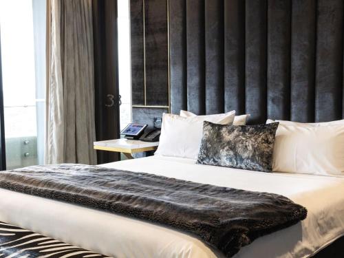 布里斯班南岸大商场购物中心酒店的一间卧室配有一张大床和大床头板