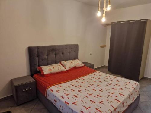 乌季达EVO résidence的一间卧室配有一张带红色和白色棉被的床