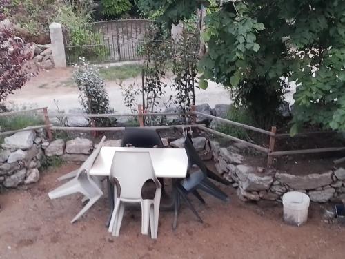 卡拉库恰Maison de caractère au coeur de la corse rurale的院子里的白色桌子和椅子