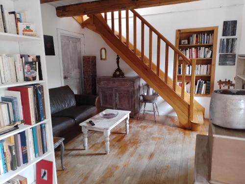 卡拉库恰Maison de caractère au coeur de la corse rurale的客厅设有楼梯、沙发和桌子