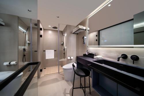 深圳深圳罗湖东门君亭尚品酒店的一间带水槽、卫生间和镜子的浴室
