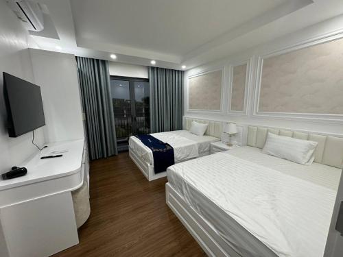 广宁Lavender Sonasea Vân Đồn, Quảng Ninh的酒店客房设有两张床和电视。