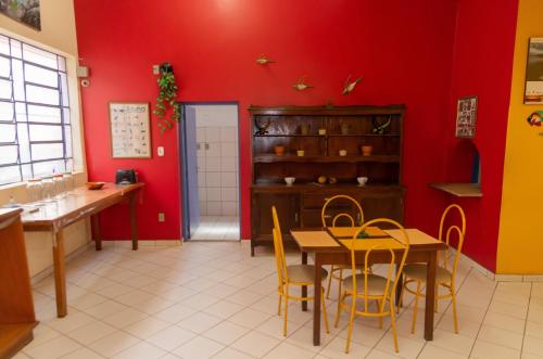 戈亚尼亚Goiânia Palace Hotel的一间拥有红色墙壁和桌椅的用餐室