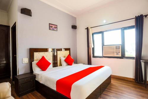 SohnaSuper Collection O 1064 Tipsyy Inn Suites 17的一间卧室配有一张带红色枕头的大床