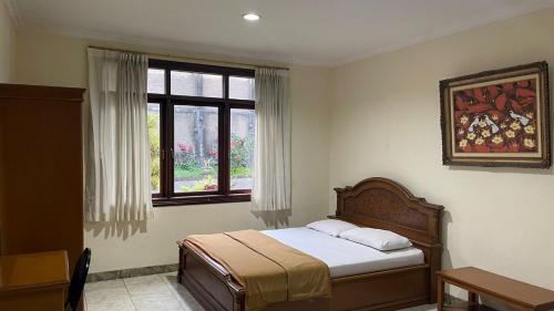 PanyaweuyanGreen Hill Resort Kemuning的一间卧室设有一张床和一个窗口