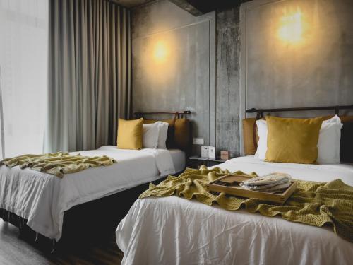 乔治市Hotel Mokozoyo的酒店客房设有两张床,并备有托盘。