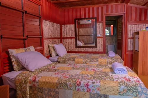 南迪Tahals Holiday Villas的一间红色客房内带两张床的卧室