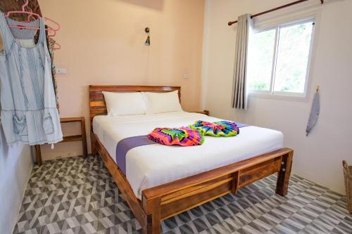 高兰Enda Lanta Bungalows的一间卧室配有一张带白色床单的床和一扇窗户。