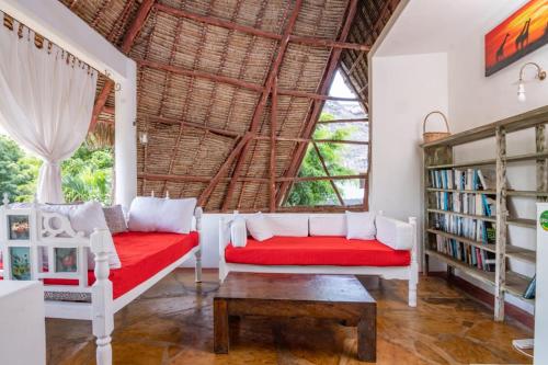 马林迪Minimi Couzy villa casaurina的客厅设有红色的沙发和大窗户