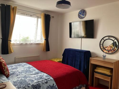 邓迪Dundee City Waterfront, 2 Bedroom 2 Bathroom Apartment - short walk to V and A, Bus & Train Stations的一间卧室配有一张带红色毯子的床和窗户。