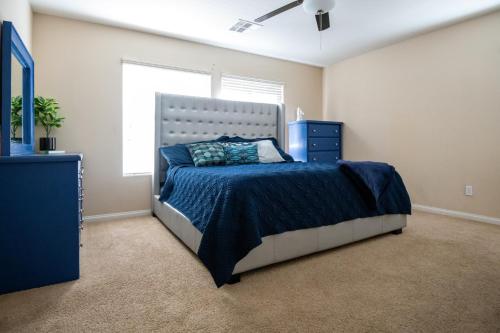 拉斯维加斯Large 3BR King Suite Moments Away From Strip的一间卧室配有一张带蓝色棉被的床和窗户。