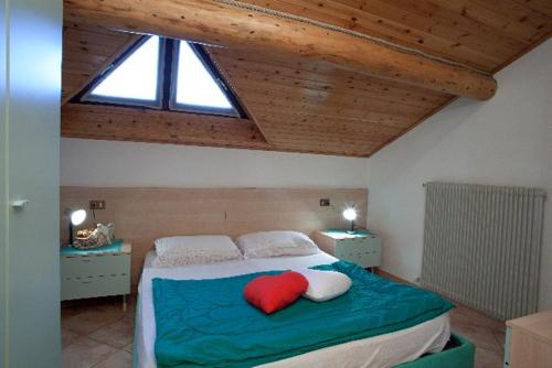 利维尼奥VERDELAGO Appartamenti e CASA CRY的一间卧室配有一张红色枕头的床